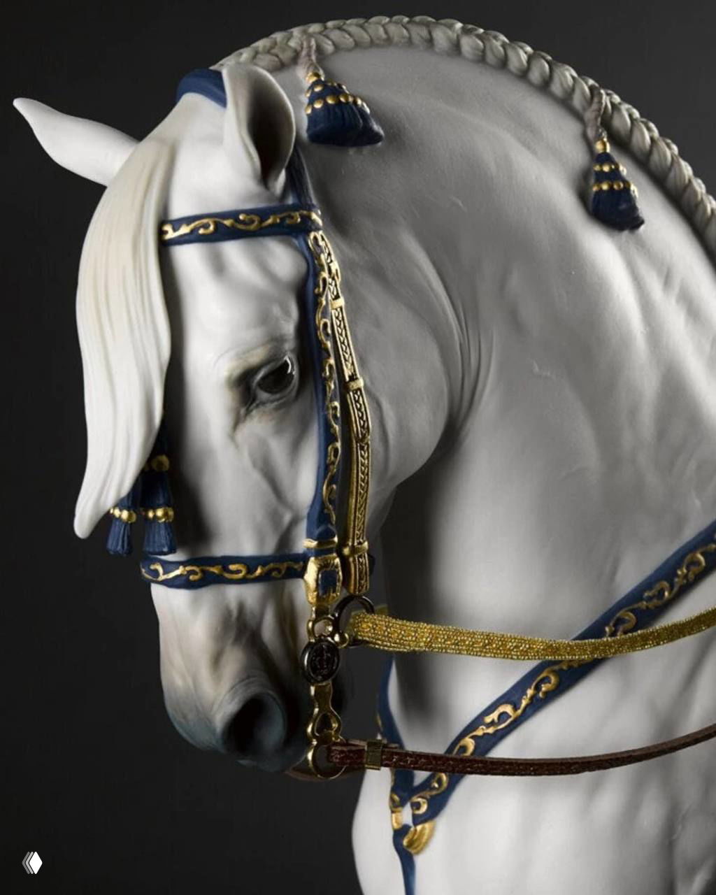 Крупный план фарфоровой скульптуры головы лошади с синими и золотыми украшениями у уздечки — декоративный объект в коллекции.