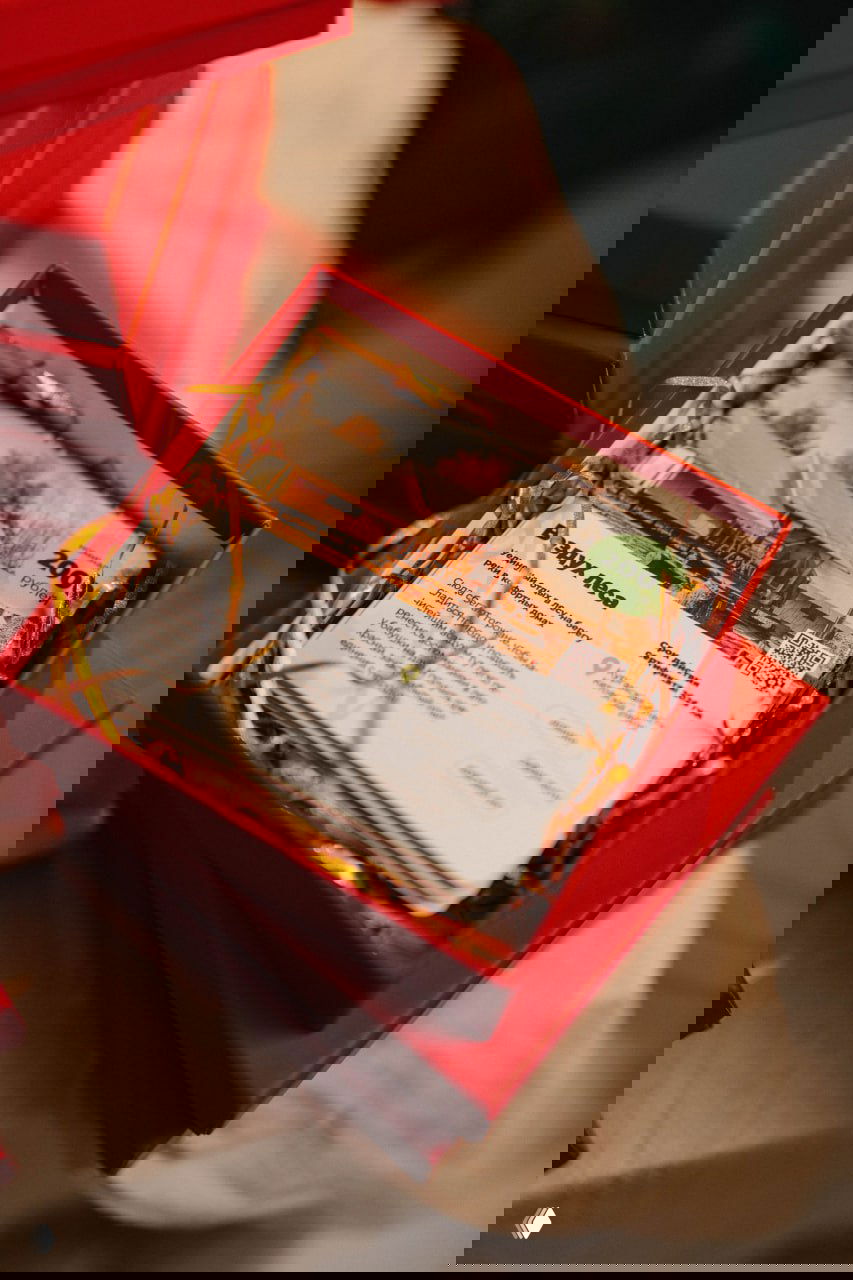 Открытая коробка Glamping Box с набором карточек и оформлением из золотой бумаги — внутри сертификаты и путеводитель по локациям.