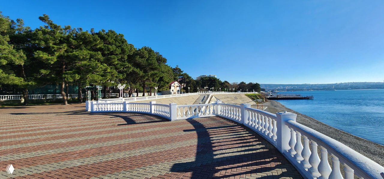 Набережная Геленджика: широкая прогулочная зона с балюстрадой, вид на море и пирс, набережная в солнечный день и открытый морской горизонт.