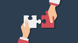 Иконка: две руки соединяют детали пазла, метафора объединения и сотрудничества, подходящая к объяснению значений join и be joined to.