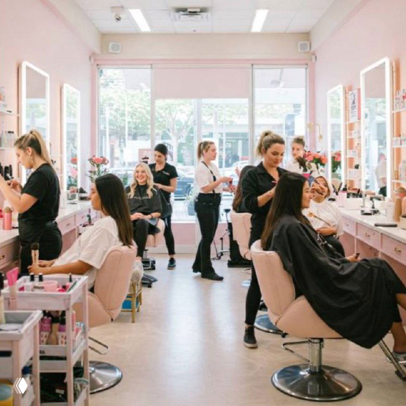 Фото заполненного салона красоты: мастера за рабочими креслами, клиенты в приёме, видна интенсивная загрузка и график.