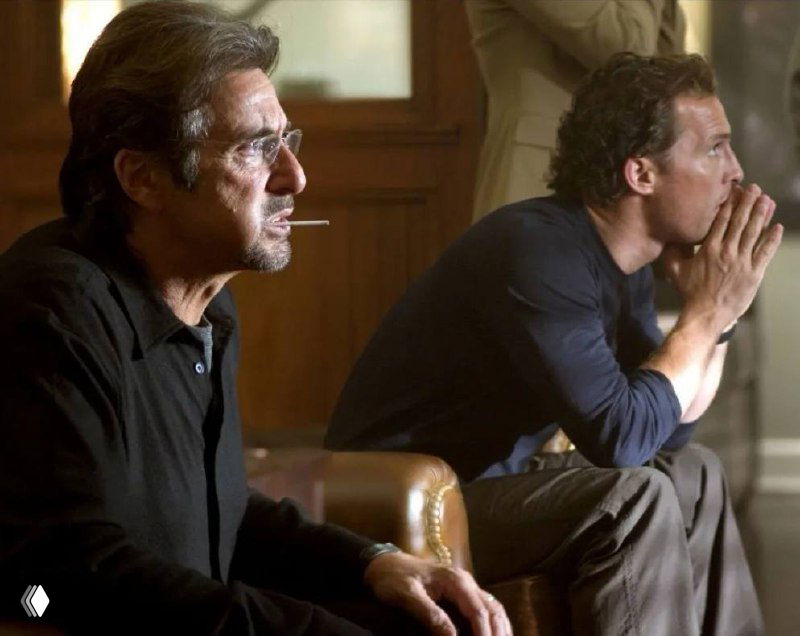 Два мужчины в разговоре в интерьере, изображение частично искажено; сцена создаёт ощущение напряжённой деловой беседы.