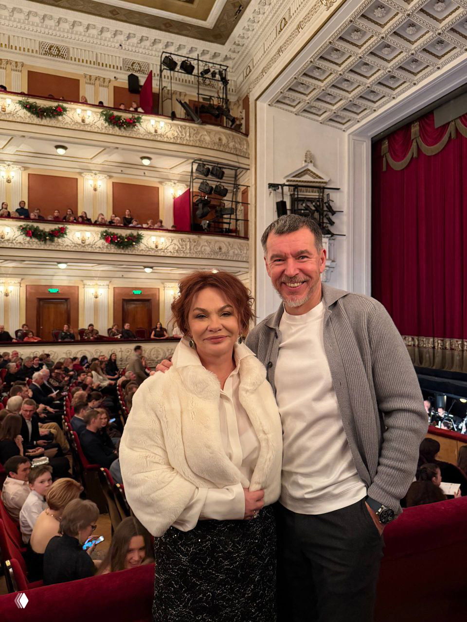 Посетители в фойе на фоне зрительного зала и балконов Пермского театра оперы и балета: вид интерьера и публики перед спектаклем.