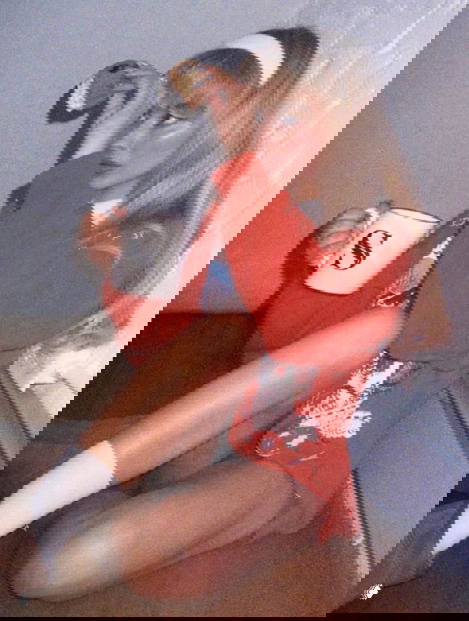 Молодая женщина сидит на полу с кружкой и печеньем, образ в мягких тонах и повседневном стиле, съёмка в домашней атмосфере.