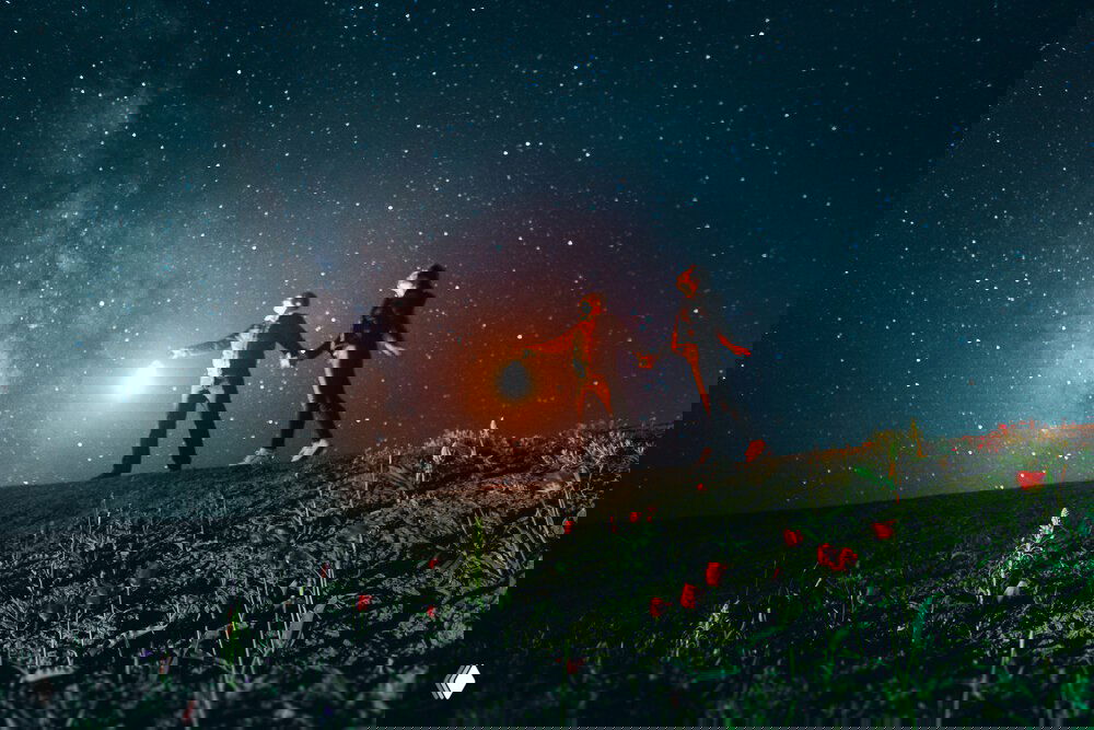 Ночная сцена: двое человек с фонарём на цветущем холме, звёздное небо и Млечный Путь над крымским ландшафтом — авторские кадры Андрея из Крыма.