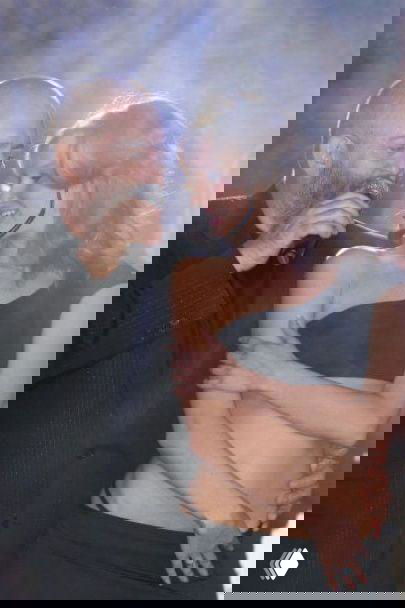 Михаил Шуфутинский на сцене с микрофоном обнимает танцовщицу Светлану Уразову во время выступления — сценный кадр с контрастным светом и эмоциями.