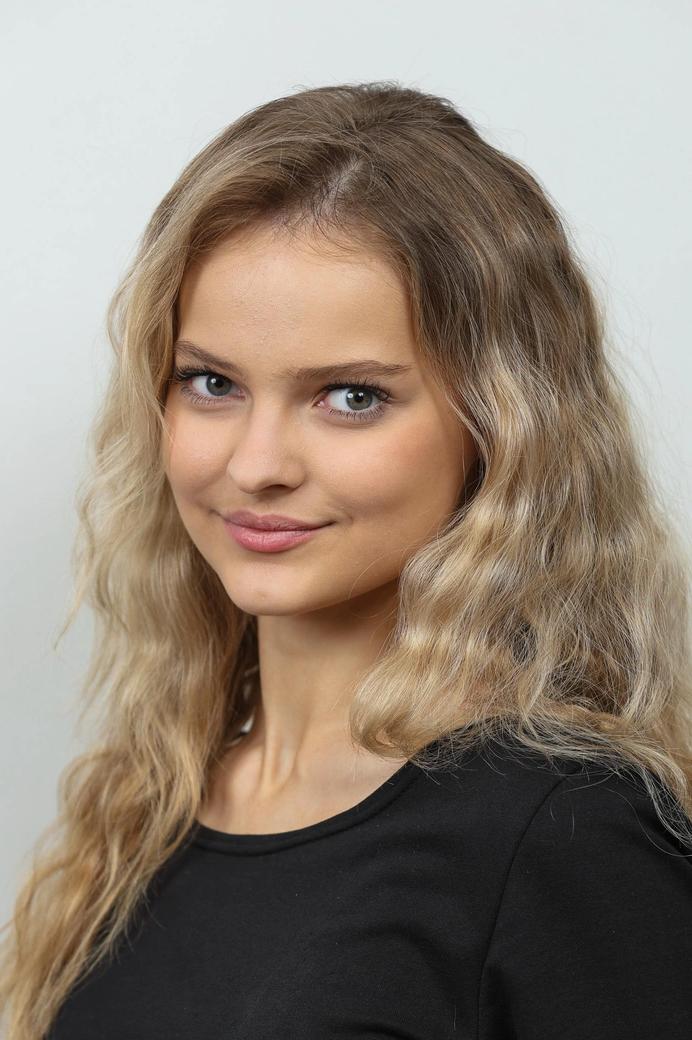 Портрет участницы финала «Мисс Татарстан‑2026»: светлые волны волос, выразительные глаза и аккуратный макияж на нейтральном фоне студии.