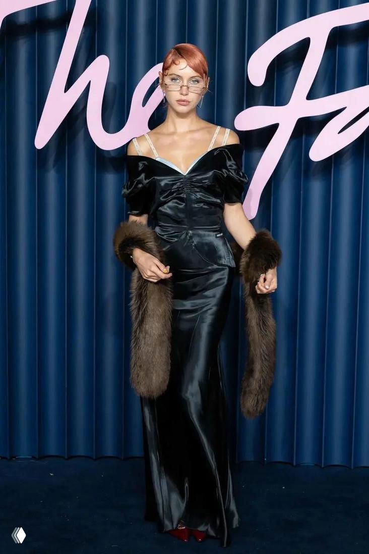 Глянцевый снимок модели в длинном атласном платье на фоне брендовой инсталляции, полный рост, fashion-образ.