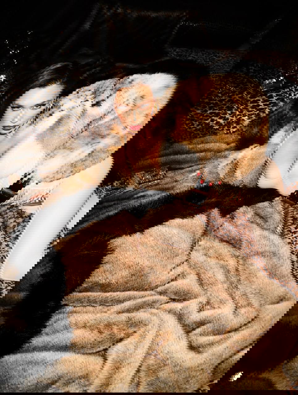 Крупный план женского образа в бежевом белье и шубе на фоне меховых покрывал и леопардового принта — студийная фотосессия.