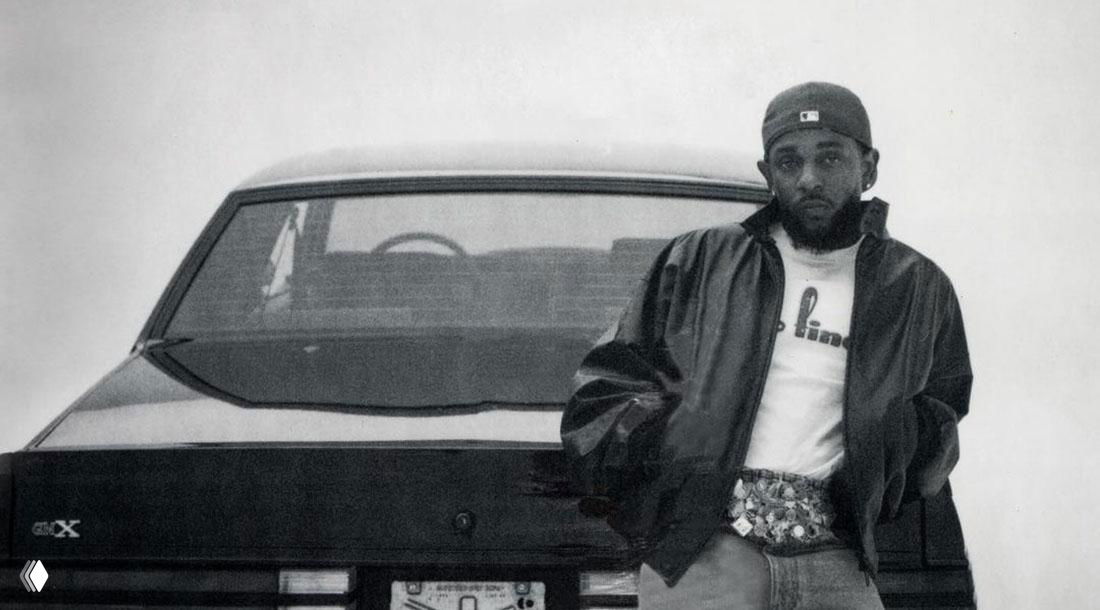 Чёрно-белое фото Кендрика Ламара, опирающегося о заднюю часть автомобиля; иллюстрация к заметке о выпадении рэпа из чарта Top-40 США.
