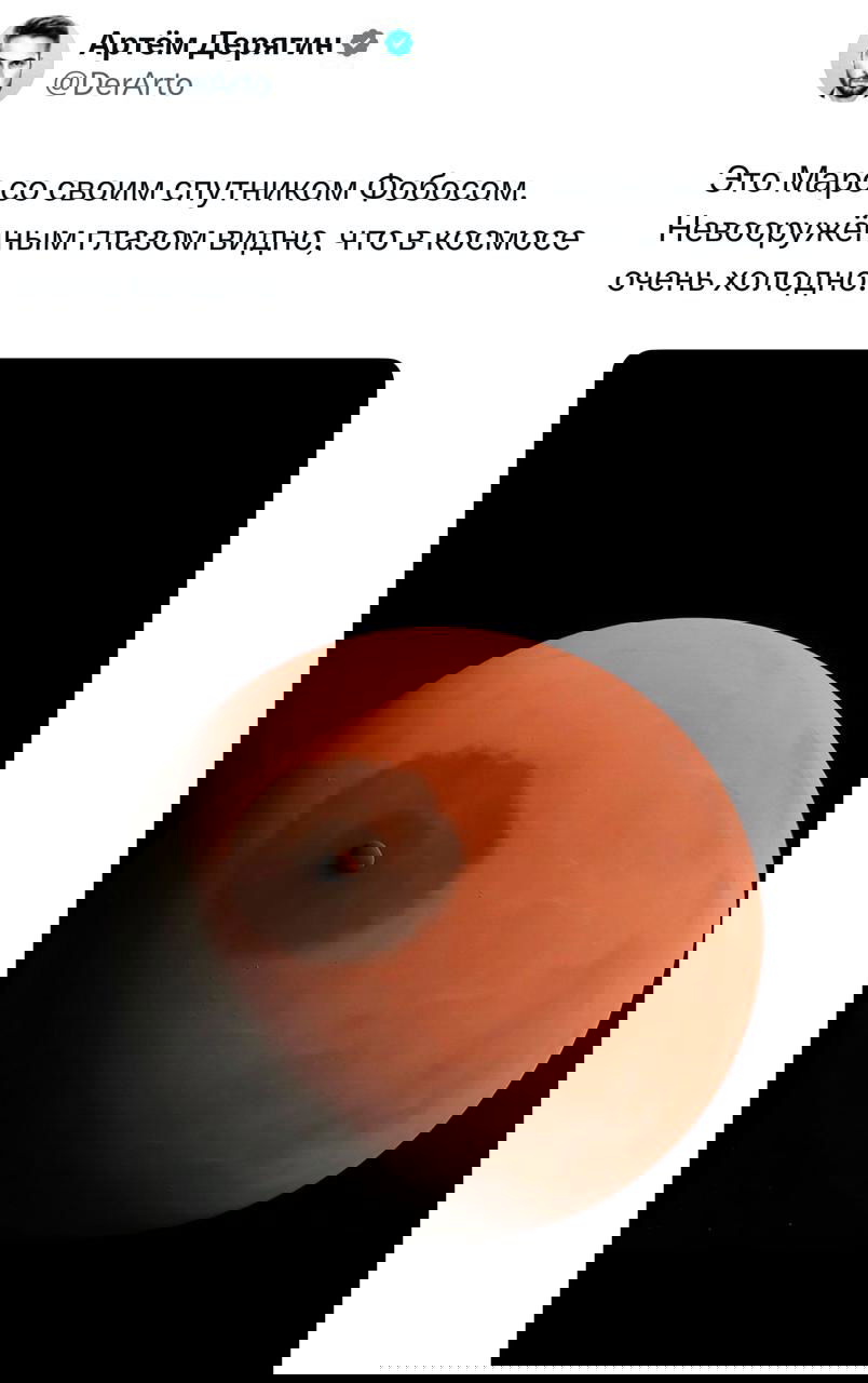 Изображение Марса с видимым спутником на фоне чёрного космоса; скриншот твита с подписью о холоде в космосе и спутнике Фобосе.