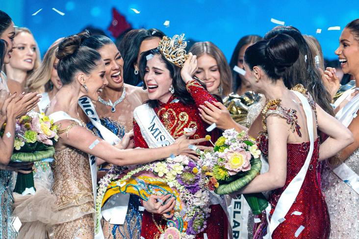 Момент коронации «Мисс Вселенная‑2025»: победительница в короне и ленте на сцене, окружённая финалистками с букетами и аплодисментами.