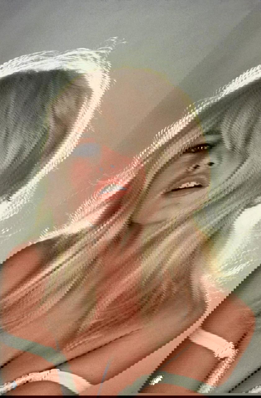 Портрет Бриджит Бардо с распущенными волосами и выразительным взглядом, цветная студийная фотография и крупный план лица и груди.