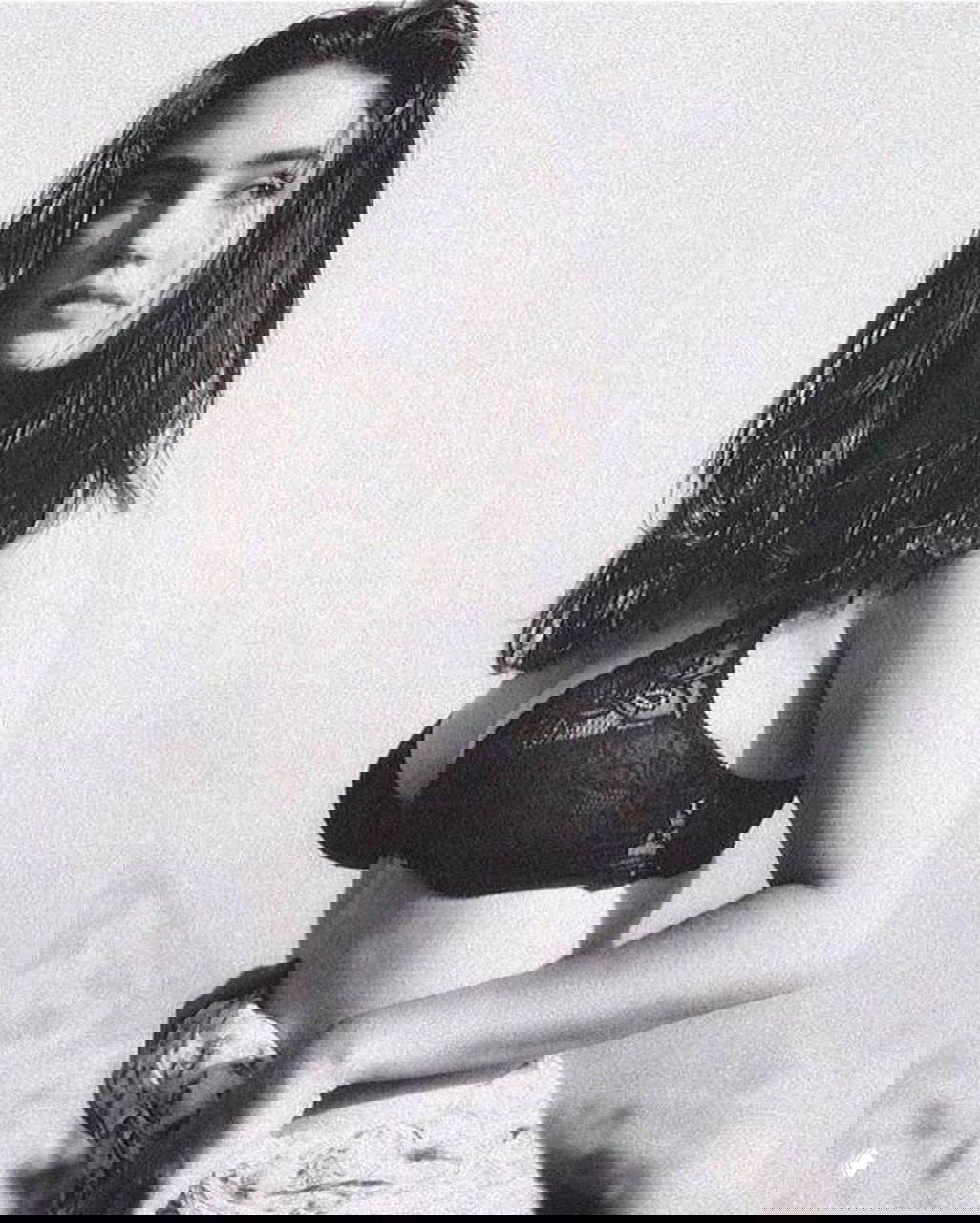 Чёрно‑белая фотография женщины в кружевном бюстгальтере, классический кадр 1990‑х с мягким контровым светом и выраженной зернистостью.