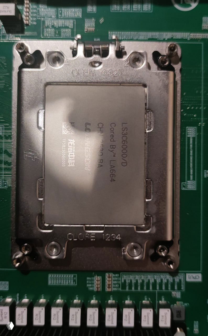 Макро-снимок установленного процессора с маркировкой LS3C6000/D на креплении сокета; явно читается обозначение модели и часть крепежной рамки вокруг CPU.