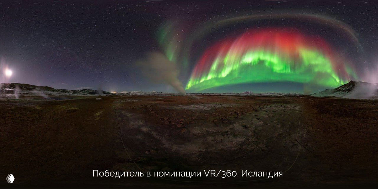 Широкая панорама полярного неба над равниной в Исландии с ярким кольцом северного сияния и открытой, почти сферической передней частью ландшафта.