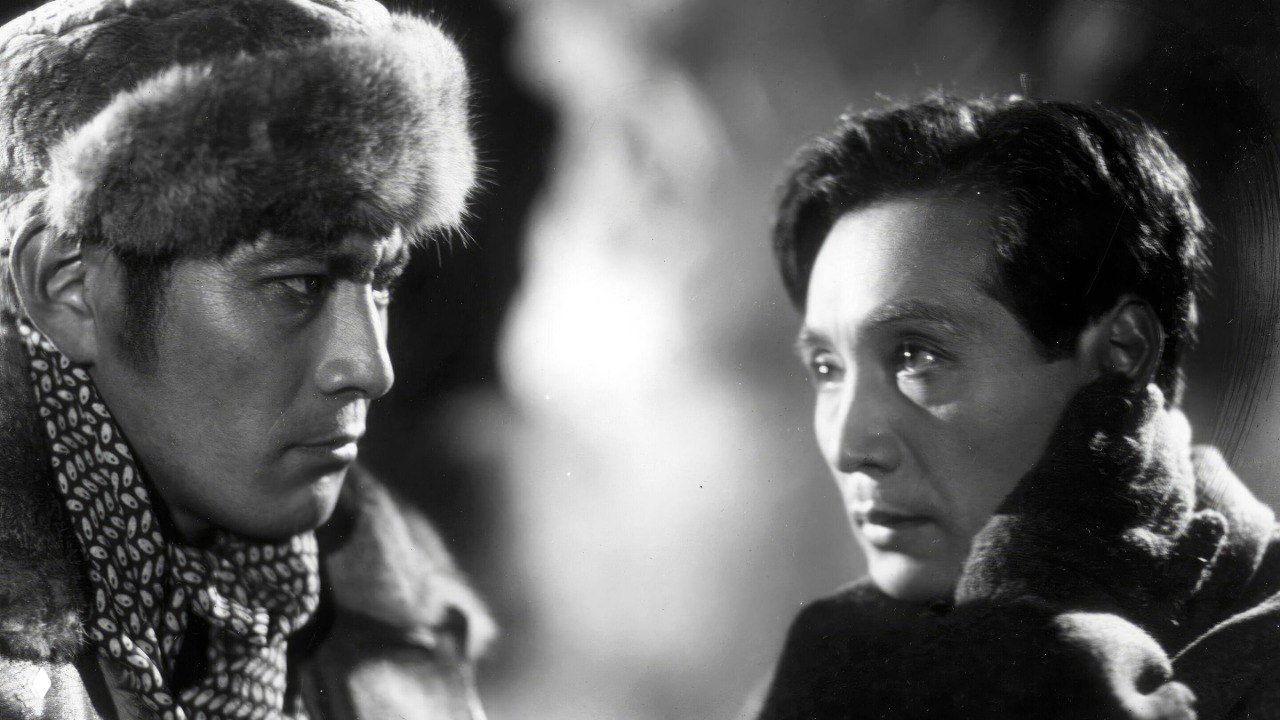 Чёрно‑белый кадр из зарубежной экранизации русской классики: два актёра в зимней одежде в напряжённой сцене на морозе.