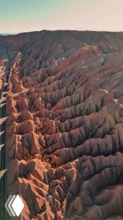 Аэрофотоснимок сухих оврагов и рифтов красно-коричневых пород в центральной части пустыни Атакама с выраженной эрозией почвы.