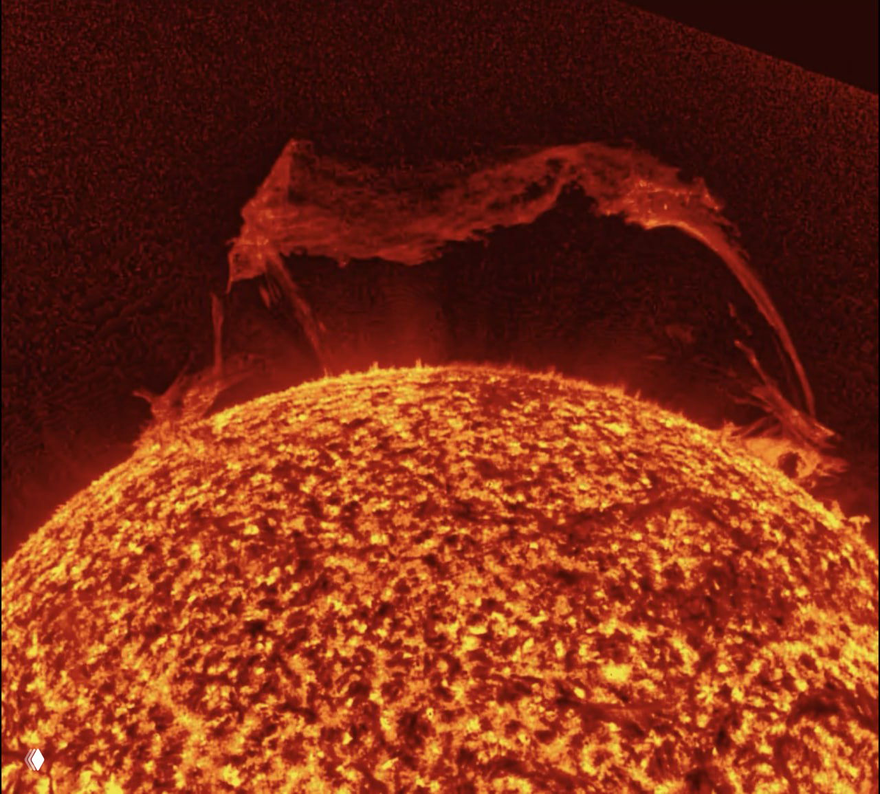 Изображение Солнца с гигантским «царь‑протуберанцем» у край звезды: арочная структура и плотный плазменный сгусток плазмы над поверхностью Солнца.