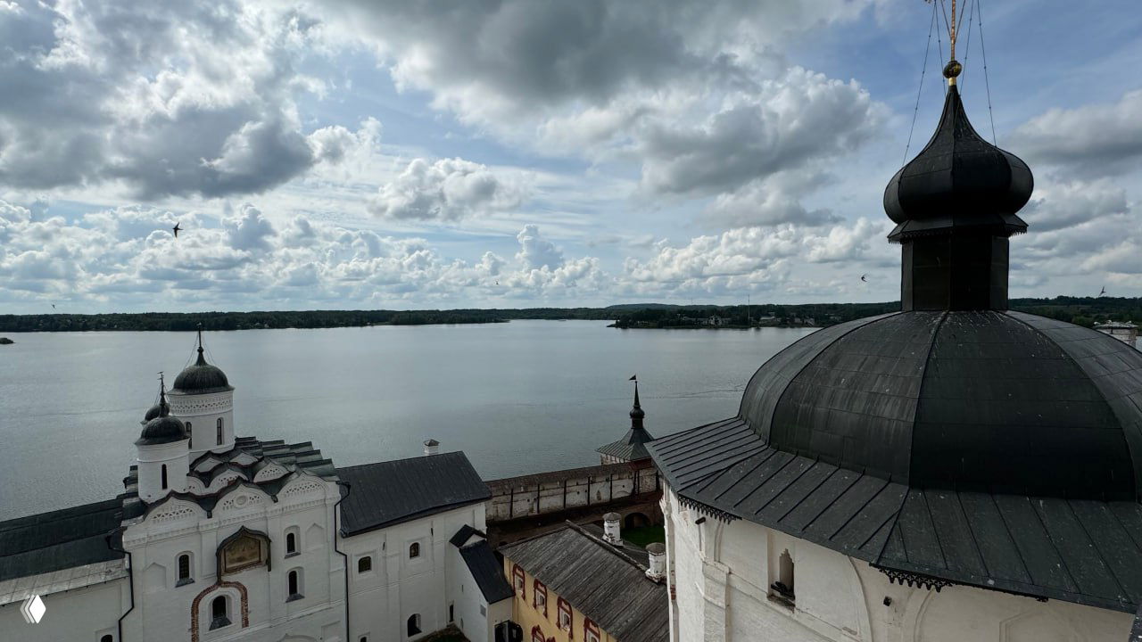 Купол и крыша одного из соборов монастыря на фоне открытого Сиверского озера, вид сверху демонстрирует расположение обители на берегу озера и мощные оборонительные стены.