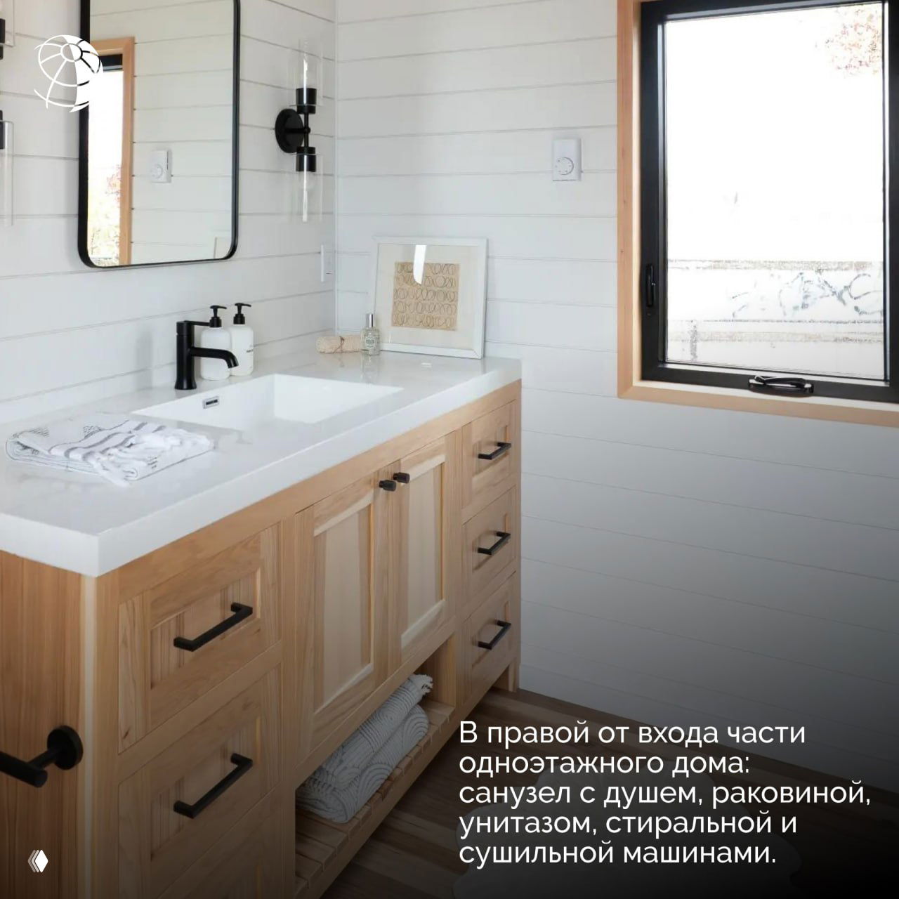 Санузел дома‑прицепа с раковиной, душевой зоной и деревянной тумбой хранения — компактное и светлое пространство для гигиены и стирки.