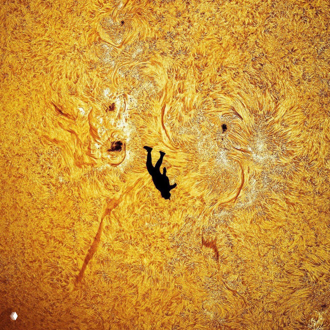 Крупный план структуры поверхности Солнца с яркими активными областями и детализированной текстурой; в центре — чёткий чёрный силуэт падающего человека.