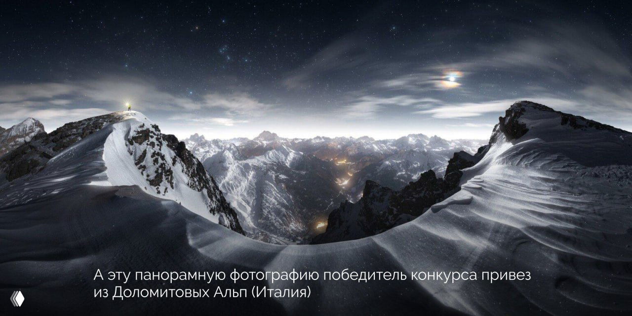 Панорама заснеженных вершин Доломитовых Альп ночью: снятие с высокой точки, изгибы снега и мерцающие огни в долине под звёздным небом.
