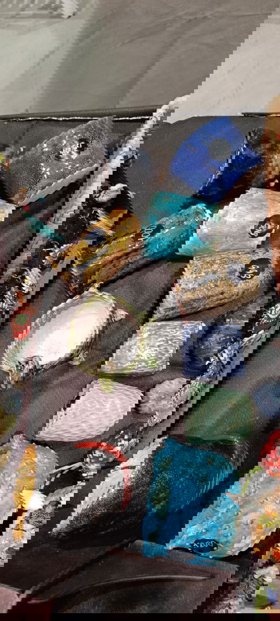 Глазурованные керамические чаши и мини-кашпо разных форм и цветов, выложенные на тёмной ткани торгового стола цветочного маркета в Казани, видны ценники.