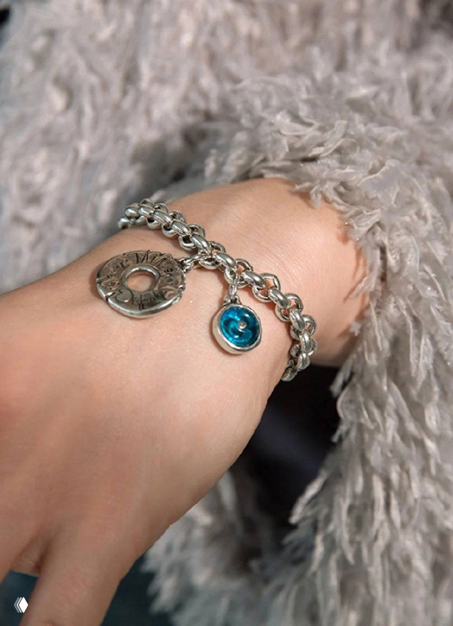 Студийная фотография одного широкого серебристого браслета Ciclon в виде эластичного панцира на белом фоне, акцент на форме и фактуре.