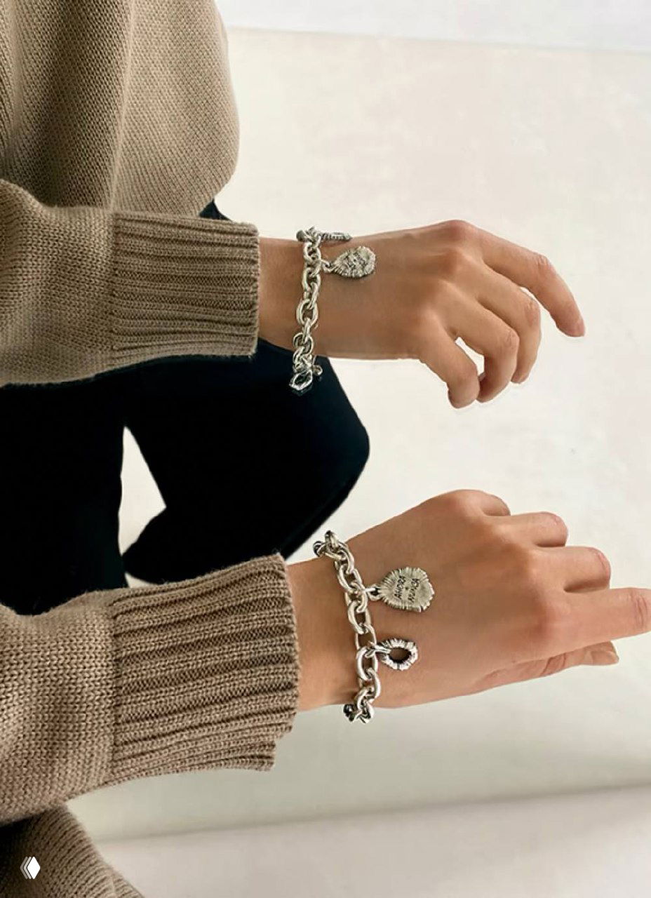 Фотография запястья, на котором надеты браслеты Ciclon: комбинирование массивных и тонких цепочек создаёт многослойный образ аксессуаров.
