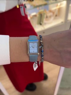 Светлый ремешок часов на женском запястье в сочетании с украшением-цепочкой, демонстрация второго варианта комплектов Coeur de Lion.