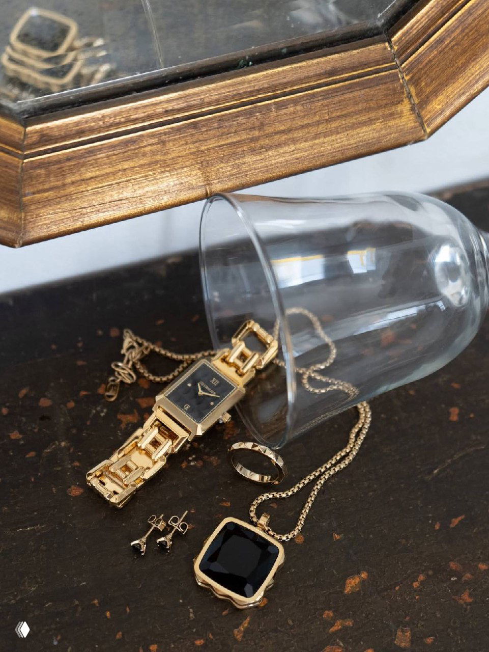 Крупный план серебряных и золотых украшений: цепочки, кольца и кулоны на тёмной фактурной поверхности, демонстрация деталей.