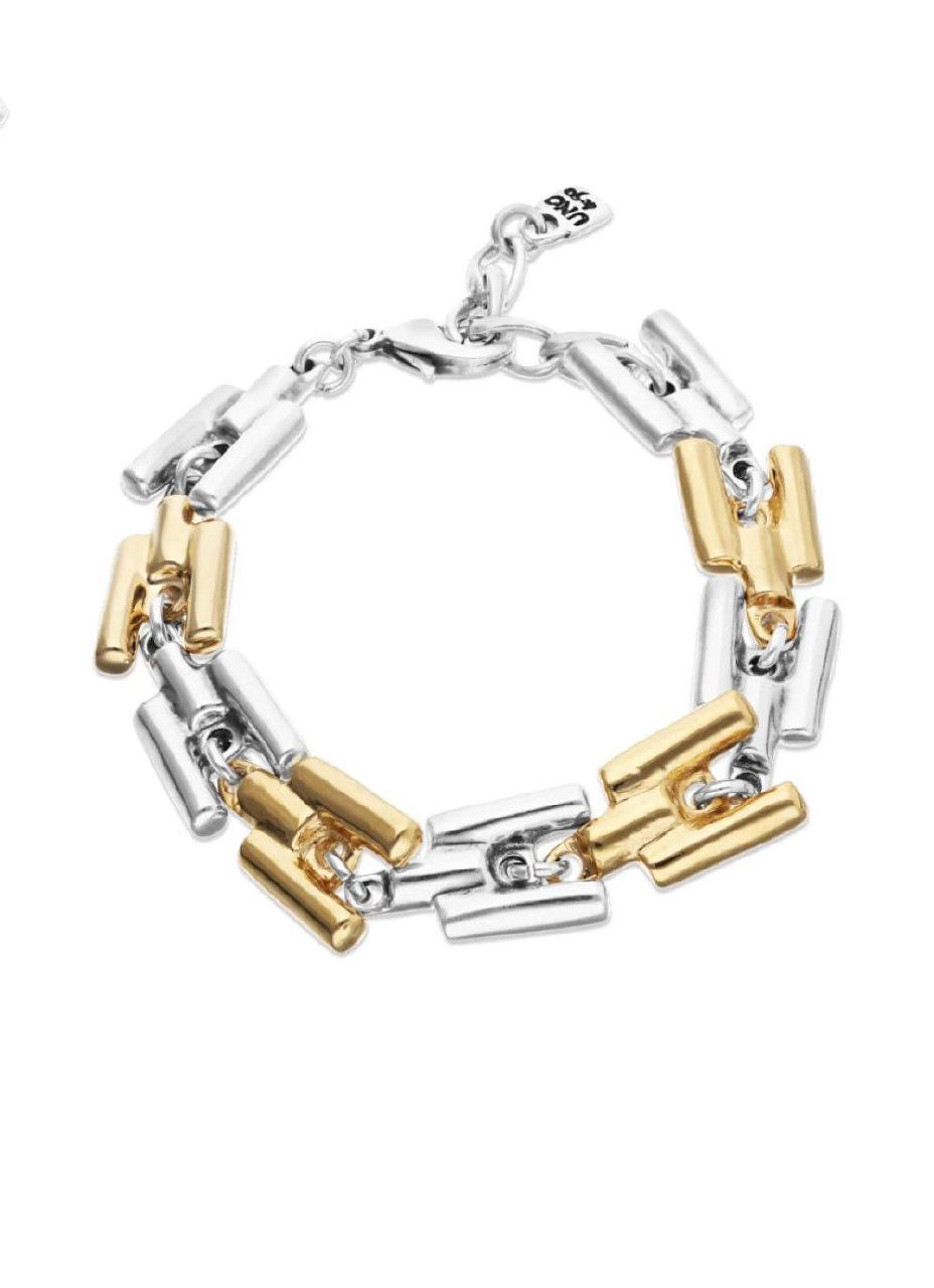 Модель демонстрирует колье и браслет коллекции ROOTS от UNOde50 на фоне лёгкой одежды; акцент на спокойной повседневной стилизации аксессуаров.