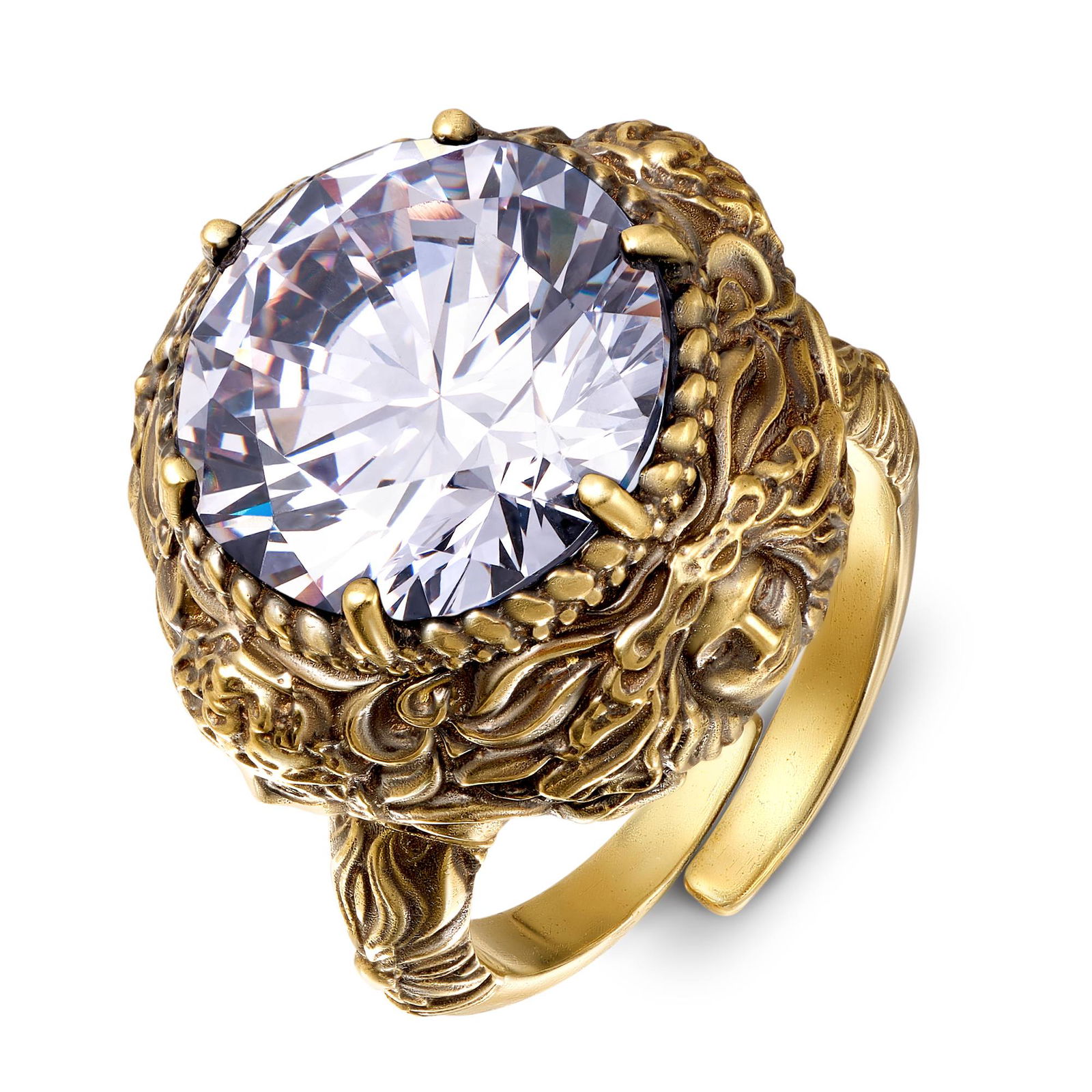 Крупный план кольца с прозрачным кристаллом в позолоченной оправе с богато прорисованными декоративными элементами и текстурой металла.