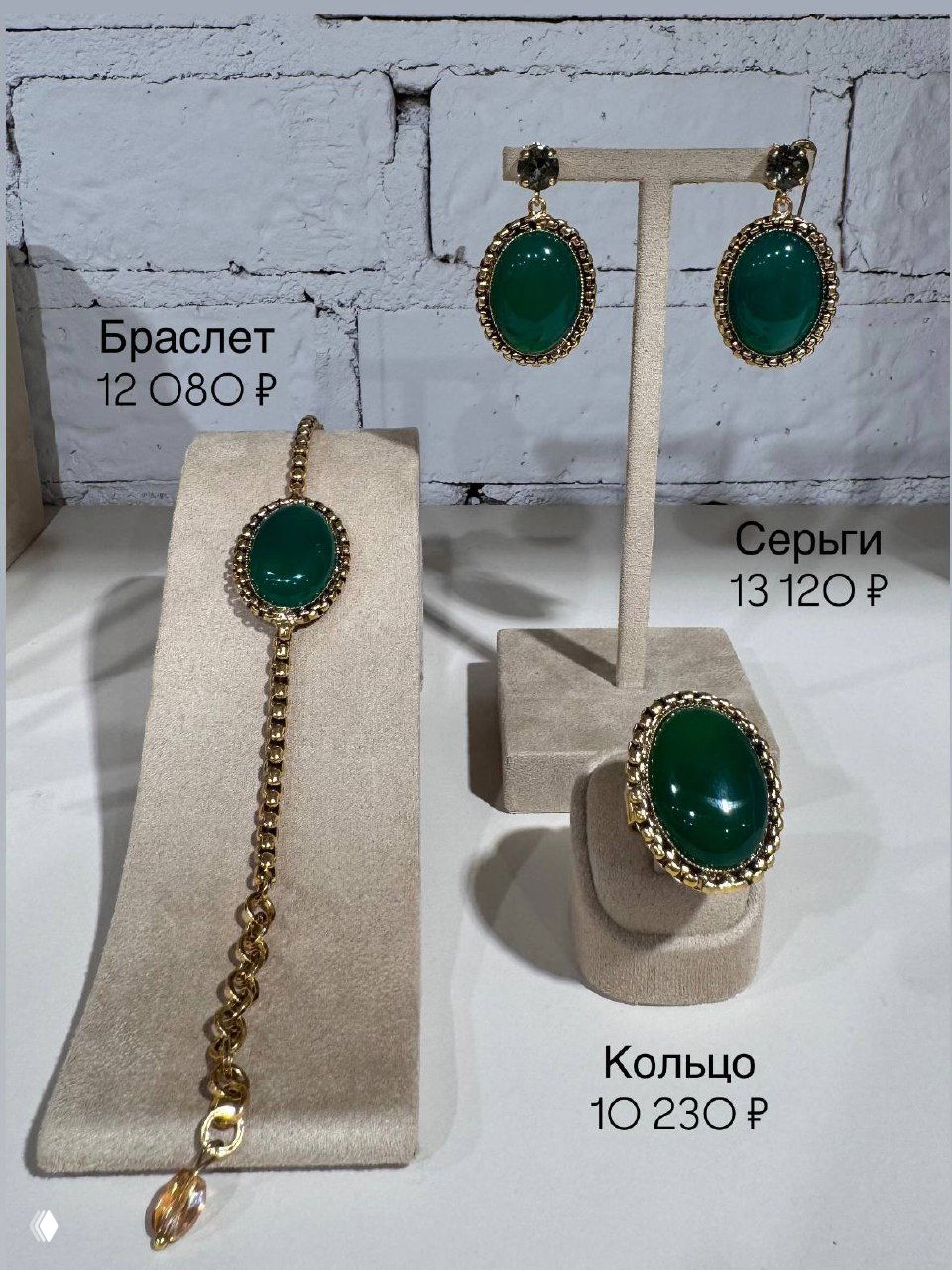 Браслет и кольцо Claudio Canzian с зелёными кабошонами на демонстрационных подставках, аккуратная выкладка в магазине Rosone с ценниками.