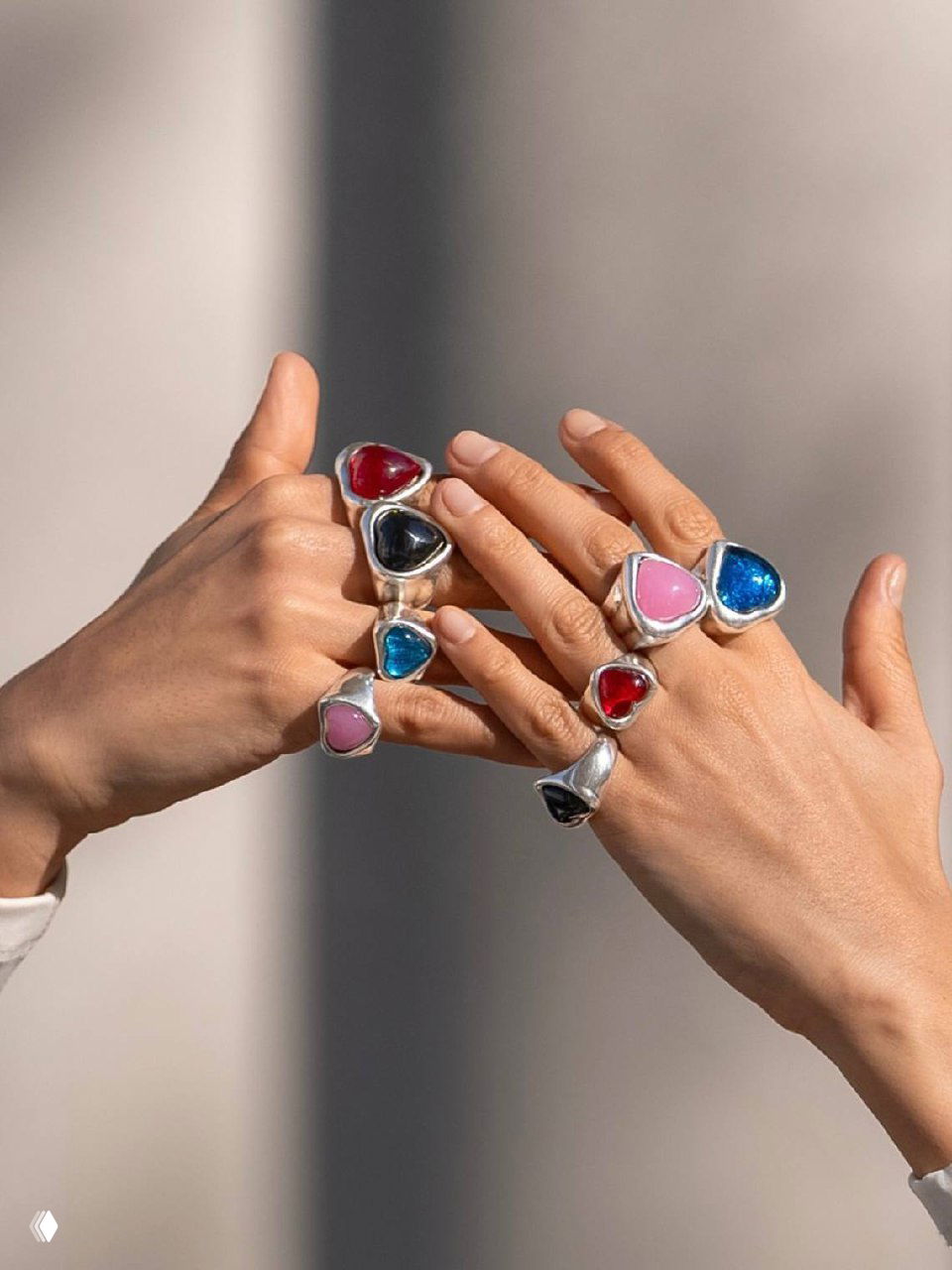 Крупный план браслета и кольца с нежно‑розовыми сердцевидными вставками, акцент на текстуре камней и полировке металла.