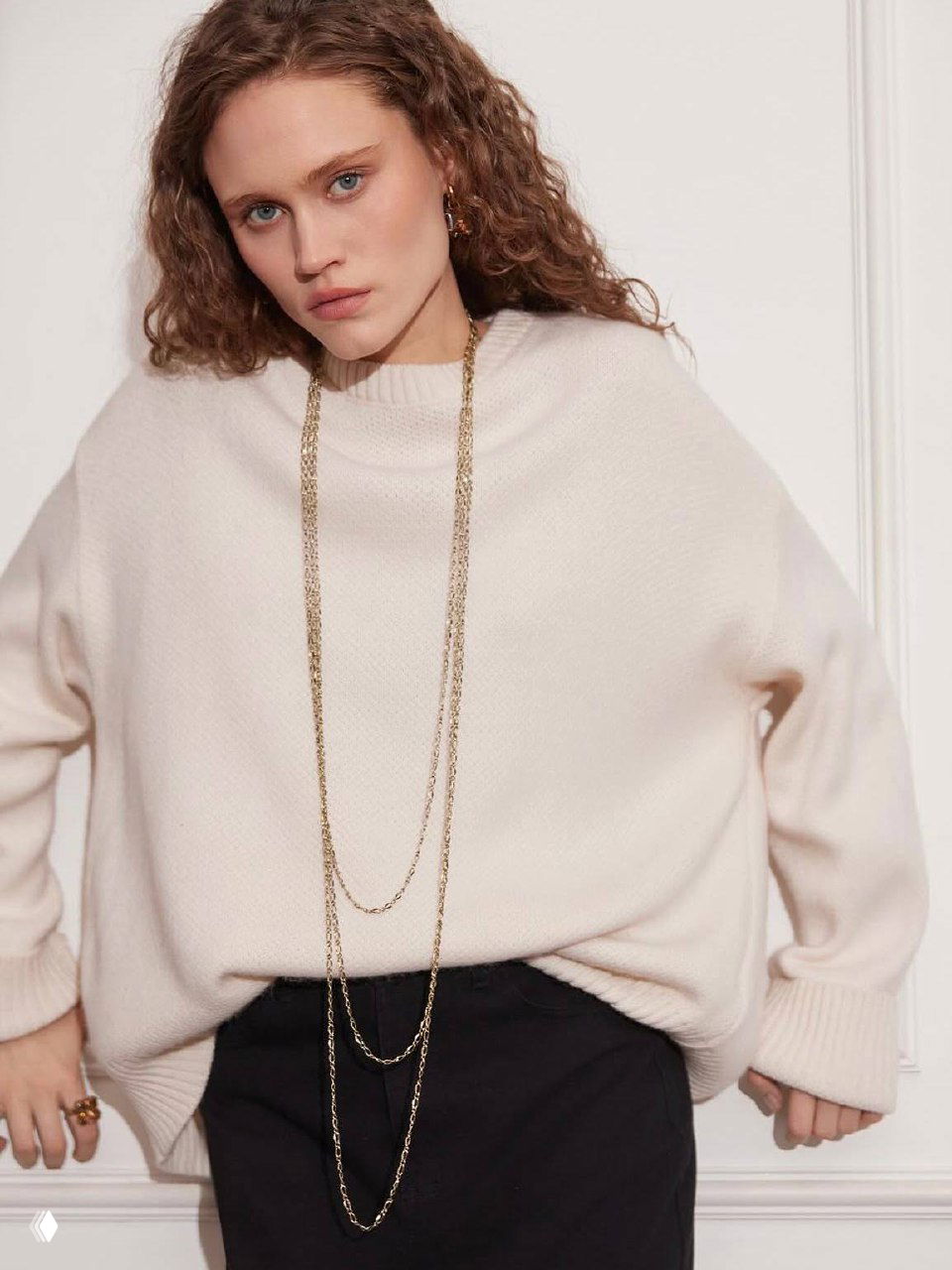 Фотоснимок модели в светлом свитере с длинными серебряными цепочками и минималистичными ожерельями Fiore di Firenze, стилизованный лук каталога ROSONE.RU.