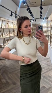 Полноразмерный снимок модели в бутике Rosone: ожерелье и серьги Claudio Canzian, позирует у зеркала, на фоне полки с украшениями.