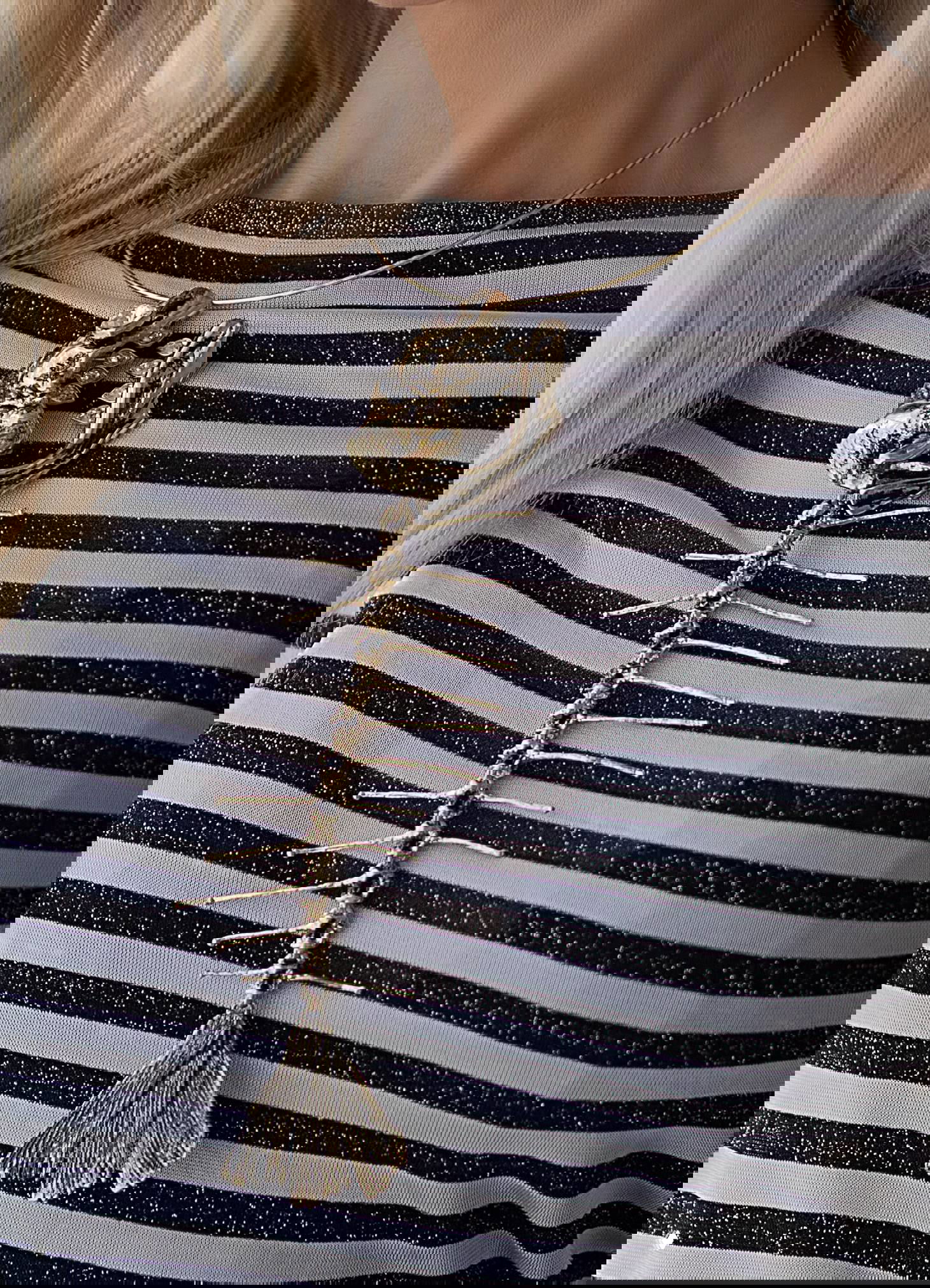 Колье «РЫБА» на модели: золотая подвеска‑скелет красиво ложится на полосатую одежду, демонстрация на шее женщины