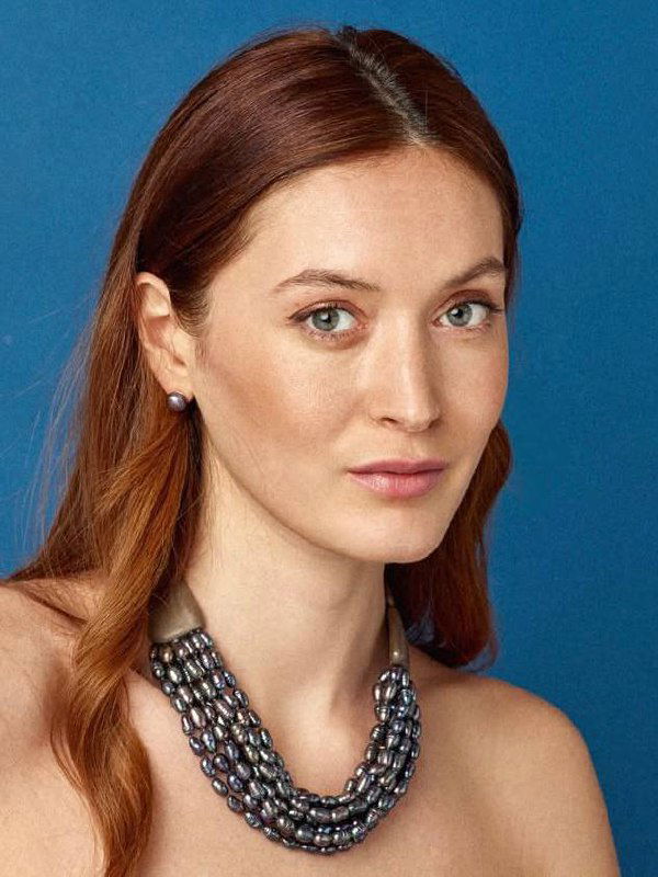 Многорядное тёмное ожерелье из натуральных камней или жемчужин на модели — показ текстуры, глубины оттенков и плотного плетения, стилистика украшений для вечернего образа.