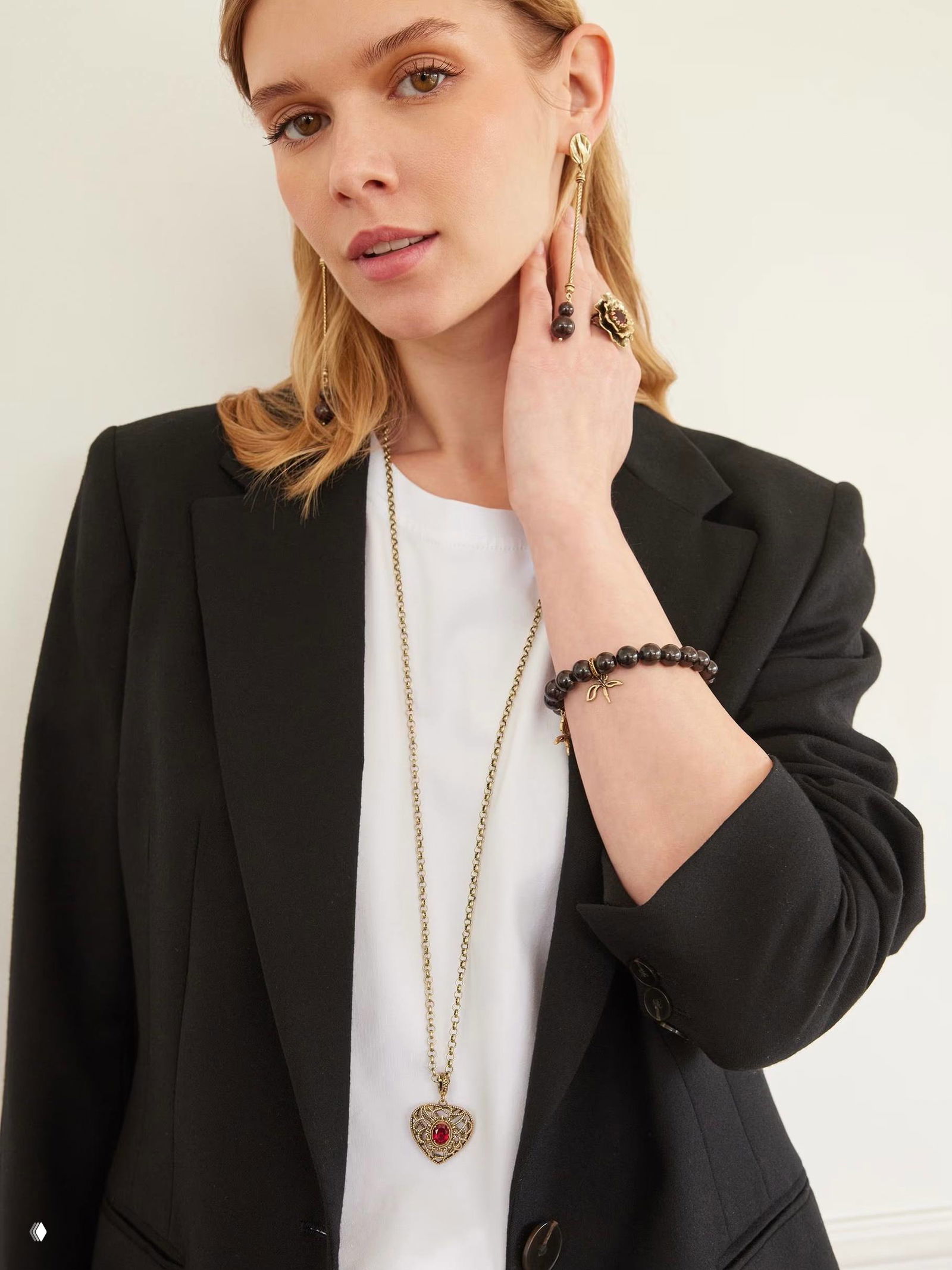 Модель в жакете демонстрирует длинную цепочку с сердцевидной подвеской AMORE ETERNO: образ для повседневного и праздничного ношения, вид в полный рост.