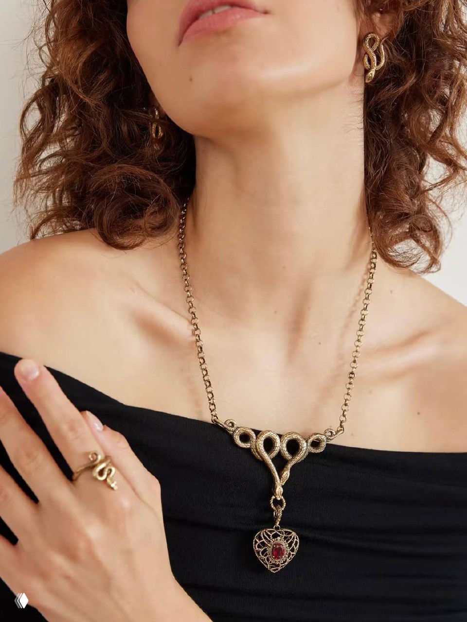 Крупный план ожерелья на груди модели: тонкая золотистая цепочка и подвеска AMORE ETERNO, демонстрация длины и посадки украшения на теле.