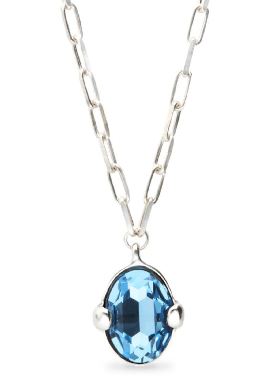 Фрагмент изящных цепочек и подвесок UNOde50: тонкие звенья, декоративные элементы и аккуратная отделка на нейтральном фоне.