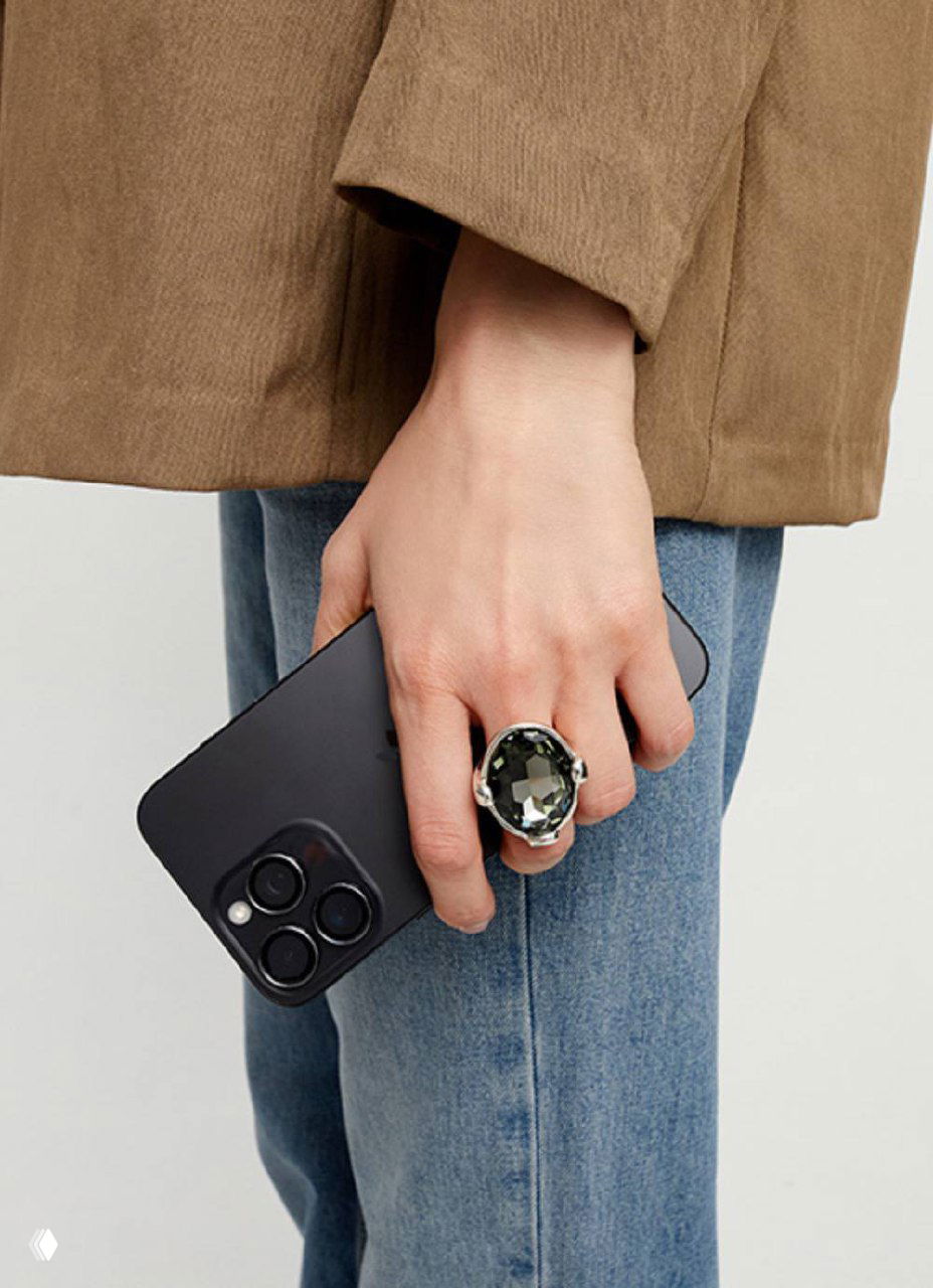 Крупный план колье с голубым кристаллом UNOde50: прозрачный камень в серебристой оправе, студийная съёмка для демонстрации деталей.