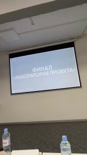 Экран с заголовком «ФИНАЛ ЛАБОРАТОРИЯ ПРОЕКТА» во время мероприятия, пустой зал и подготовка к следующей презентации.