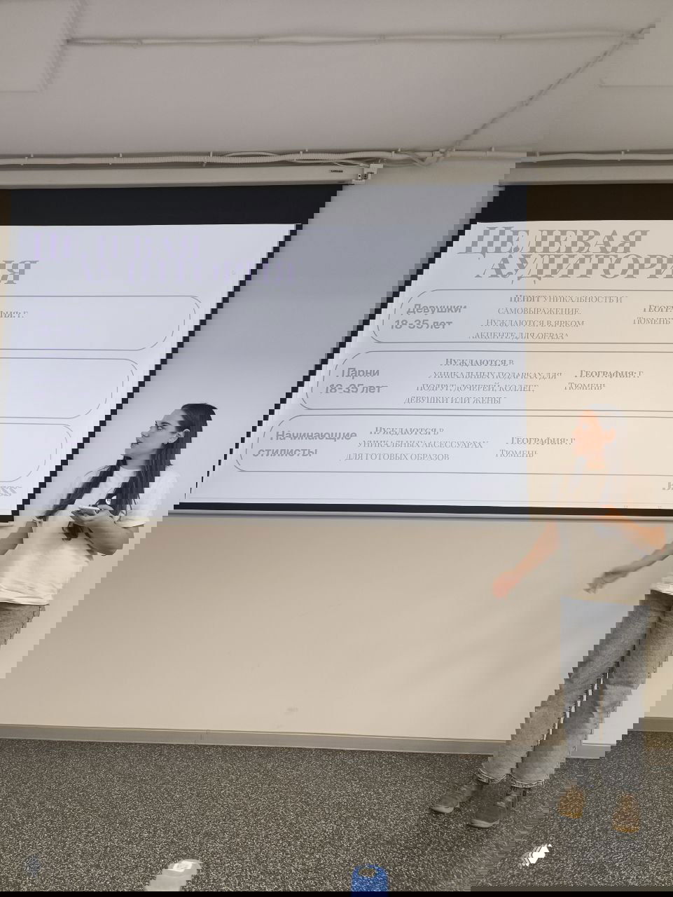 Слайд на экране с целевой аудиторией проекта: презентация, докладчик стоит рядом и озвучивает ключевые сегменты целевой группы.