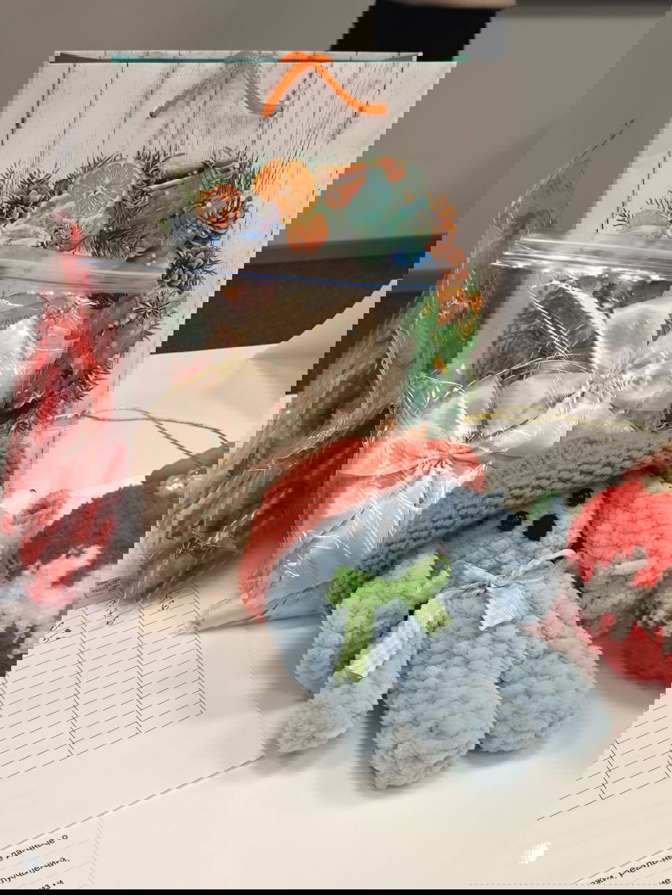 Подарки и образцы продукции команд-участниц: в кадре подарочная упаковка, мягкая вязаная игрушка и декоративные элементы.