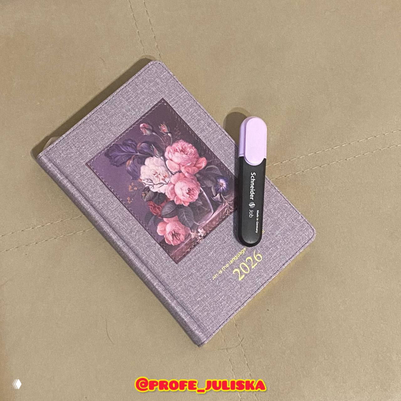 Лиловый ежедневник 2026 с цветочной иллюстрацией и фиолетовым маркером рядом; снимок показывает подарок и привычку фиксировать языковые успехи.