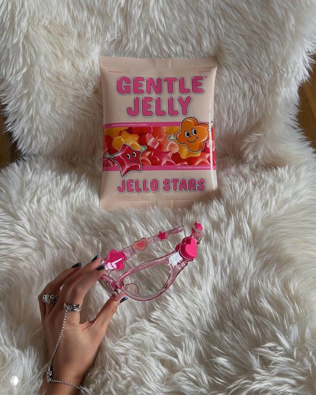 Пакет «Gentle Jelly» на пушистом фоне и прозрачные розовые очки в форме сердечек на переднем плане — акцент на желейной эстетике и аксессуарах.
