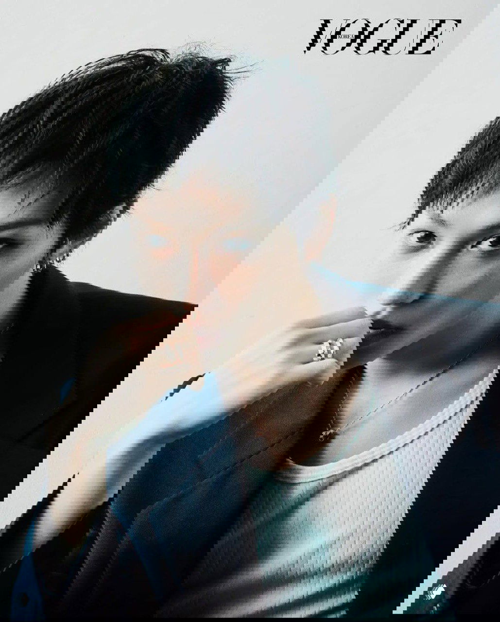 Крупный план лица модели в светлом интерьере: короткая стрижка, естественный макияж и прямой взгляд в камеру, минимализм в одежде.